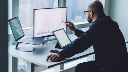 Person sitzt vor Laptop und arbeitet